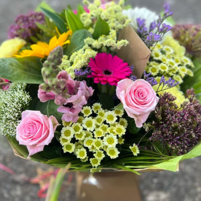 Spring Charm - Bursting with charm, this design blends pink roses, yellow sunflowers, gerbera, snapdragons and daisies in a rustic kraft wrap. A seasonal favourite. Spring Charm - Bursting with charm, this design blends pink roses, yellow sunflowers, gerbera, snapdragons and daisies in a rustic kraft wrap. A seasonal favourite.