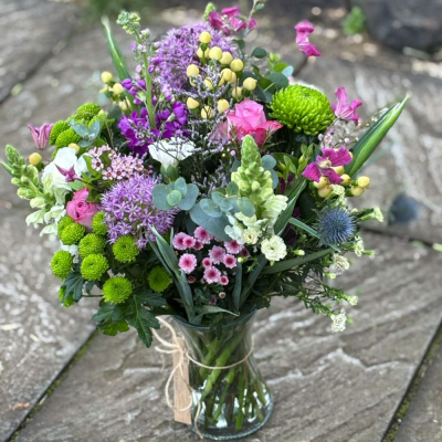 Garden Glory (Vase Included) - Presented in a clear glass vase, this lush arrangement is packed with alliums, snapdragons, thistles, green chrysanthemums, roses and foliage. A wild and wonderful celebration of nature. Garden Glory (Vase Included) - Presented in a clear glass vase, this lush arrangement is packed with alliums, snapdragons, thistles, green chrysanthemums, roses and foliage. A wild and wonderful celebration of nature.